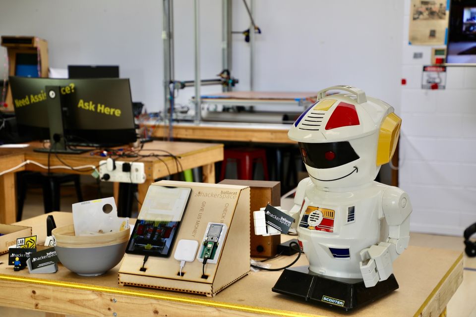 An electronics bench with test gear and a vintage robot